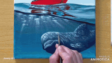 a painting of a whale is being painted on a canvas made in animatica