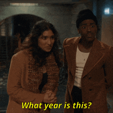 a man and a woman standing next to each other with the words what year is this written in yellow