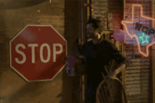 a man stands next to a stop sign
