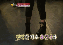 a person wearing a pair of black boots with chinese writing