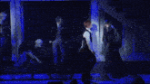a group of people are dancing on a stage with stairs behind them