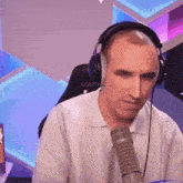a man wearing headphones sits in front of a microphone