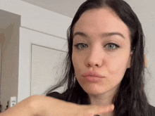 a close up of a woman 's face with her hand on her chin