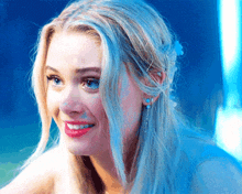 a woman with blonde hair and blue eyes is smiling