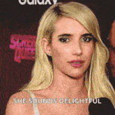a woman with blonde hair is talking into a microphone and says she sounds delightful .