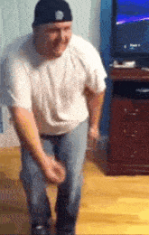 a man in a hat is dancing in a living room .