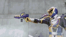a man in a purple and gold armor is holding a gun