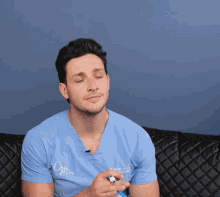 a man wearing a blue scrub top that says opm