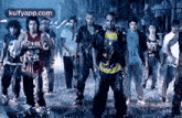 a group of people are standing in the rain in a dark room .