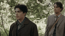 a man in a suit stands next to another man