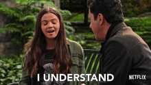 a man and a woman are sitting on a park bench and the woman is saying i understand