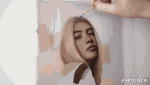 a person is painting a portrait of a woman with a brush .