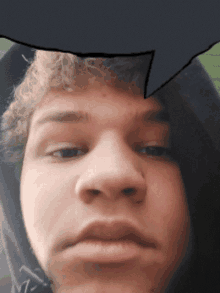 a close up of a young man 's face with a speech bubble above it