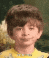 a young boy in a yellow shirt is making a funny face and saying `` ya think '' .