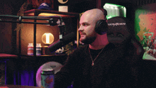 a man wearing headphones sits in front of a microphone that says dxracer