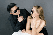 a man and a woman wearing sunglasses are posing for a photo