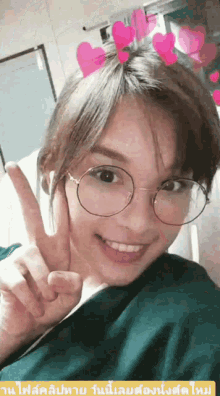 a woman wearing glasses giving a peace sign with hearts on her head