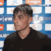 a man in a black shirt stands in front of a sign that says laliga