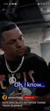 a man wearing a louis vuitton shirt is talking on a cell phone
