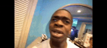 a man is making a funny face in front of a blue wall