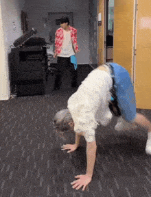 a man is doing a handstand while another man is standing behind him