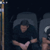 a man sits in a chair with a towel in his hand and the number 1 on the screen