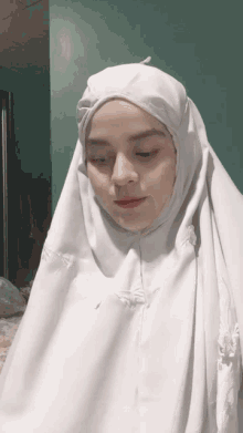 a woman wearing a white veil with a hood on her head