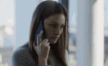 a woman is talking on a cell phone while looking down