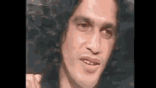 a close up of a man 's face making a funny face while looking at the camera .