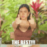 a woman is giving a thumbs up with the words " the best !!! " underneath her