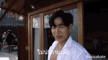 a man in a white shirt is standing in front of a window with a caption that says thisiskate