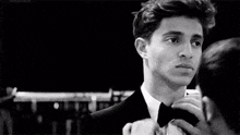 a man is adjusting another man 's bow tie .
