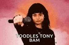 a woman is holding a microphone in her hand and says toodles tony bam