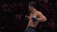 a man in a ufc boxing glove stands in a crowd