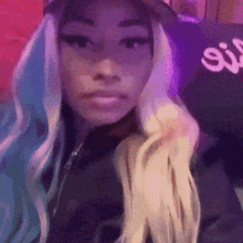 a woman with blue and white hair is wearing a hat and a black jacket .