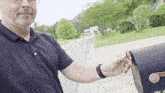 a man in a blue shirt is putting a letter in a mailbox that has the letter e on it