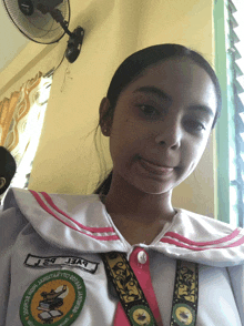 a girl in a school uniform has a badge on her chest that says j24