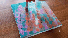 a person is painting a painting on a canvas with a brush