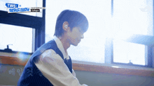 a boy sitting in front of a window with tws debut show written on the bottom
