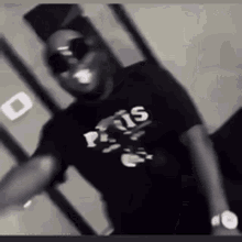 a man wearing sunglasses and a t-shirt that says ' paris ' on it