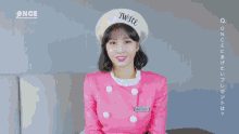a woman in a pink uniform with a twice hat on