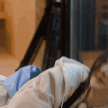 a woman is laying on a bed with a camera behind her