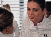 a woman wearing a lab coat with the letter a on the front