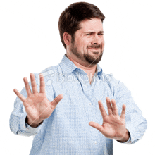 a man in a plaid shirt is making a stop sign