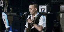 a man in a white shirt and black vest stands in front of a microphone with the words arte concert on the bottom