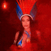 a woman wearing a feathered headdress and a body painted costume