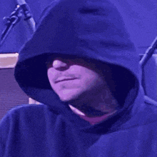 a green frog with a red mouth is wearing a black hoodie .