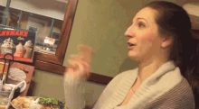 a woman sitting at a table with a sign that says milkshakes on it