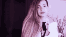 a woman with long blonde hair is wearing a white shirt and tie .