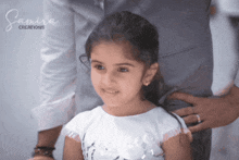 a little girl is being held by a man with the word samira creations written on the bottom